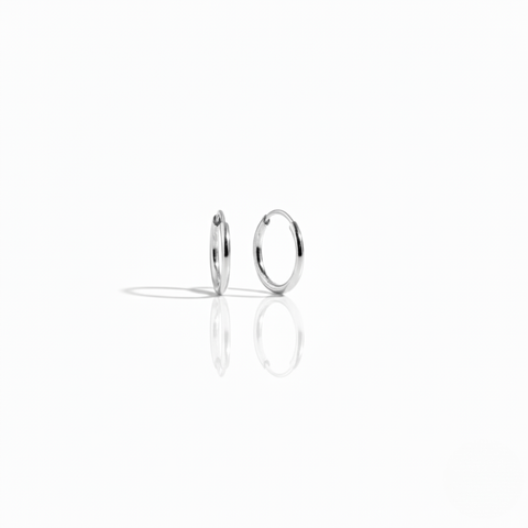 A pair of minimal polished 10K white gold Keeper Hoops on a white background, highlighting its seamless design.