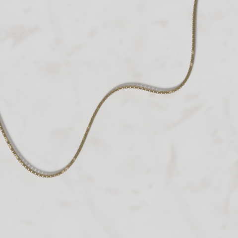 Gold chain on a light gray background