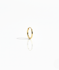 A single polished 10K yellow gold Keeper Hoop earring on a white background, highlighting its seamless, minimal design.