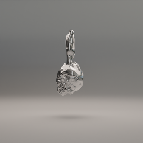 A silver and gold pendant in the shape of a flame with an intricately detailed skull design within it.
