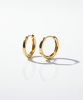 Gold minimal and rounded hoops on a white background