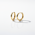 Gold minimal and rounded hoops on a white background